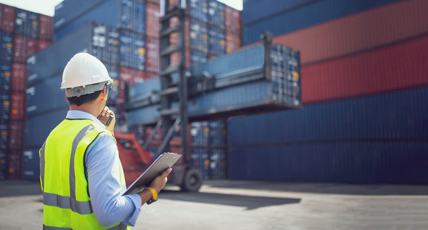 trabalhador porto de carga com capacete e colete amarelo prancheta controlo contentores exportações em Portugal 2022 atingiu recorde