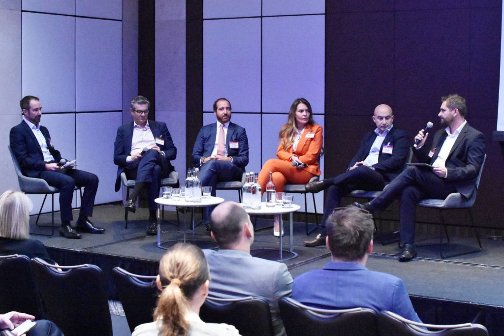 Global NPL Event in London by SmithNovak Margarida Maia CSO of Hippos Speech Panel Discussion Servicing Man Holds Microphone Debate Conference on Stage Market REO and NPL