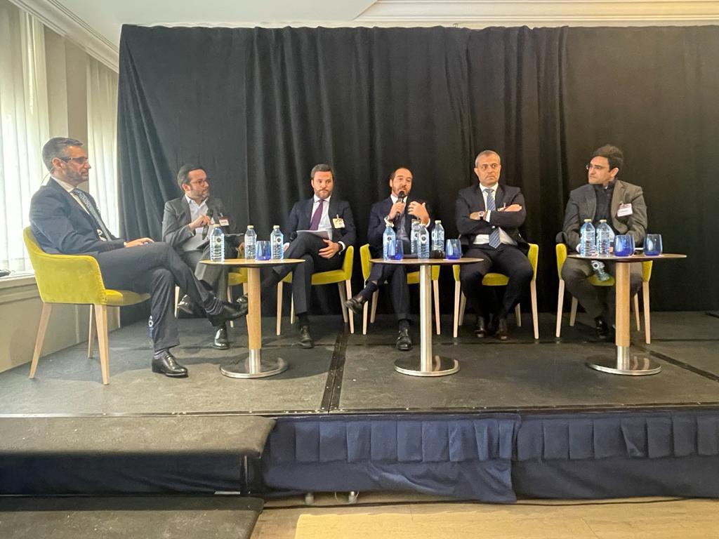 5th Annual NPL Iberia event in Madrid by SmithNovak Juan Ramon Prieto Hipoges speaker at the panel on market Servicing REO's NPLs talk stage discussion address eclectic group of men in suits